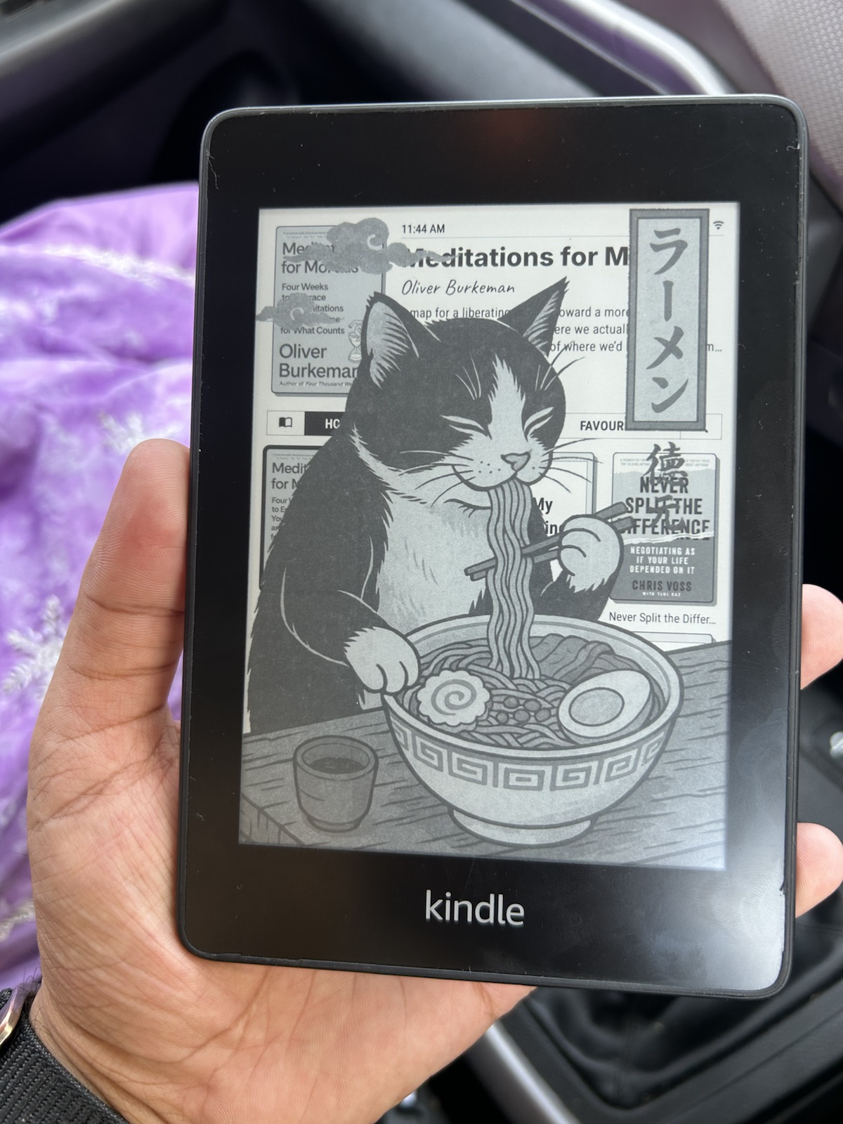 A jailbroken Kindle Paperwhite displaying a custom ramen-cat screensaver